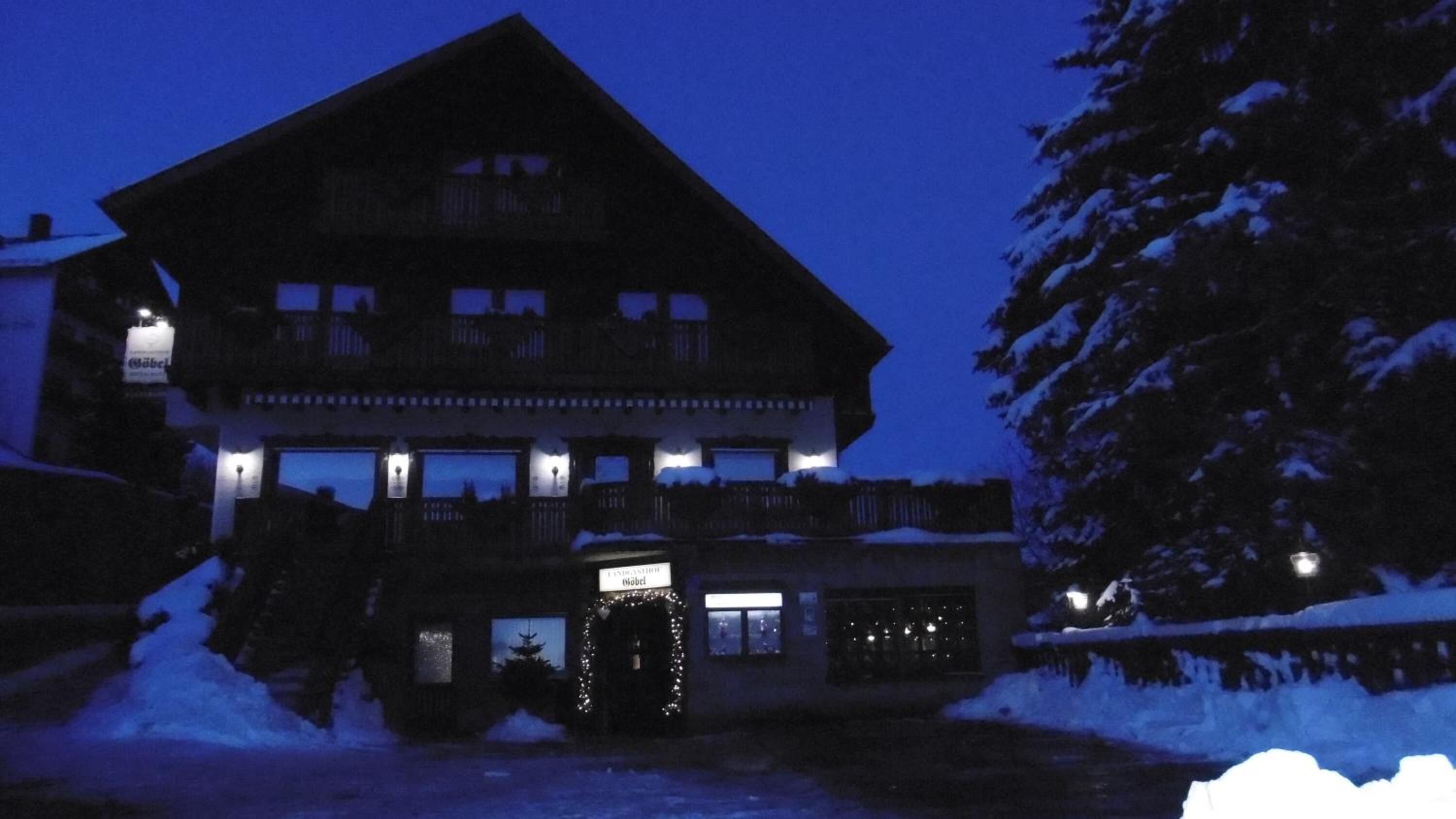 A multi-story lodge with a prominent balcony and a lit entrance.