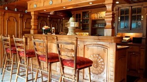 A bar area with wooden bar stools and a decorative bar counter. - Landgasthof Göbel (Willingen)