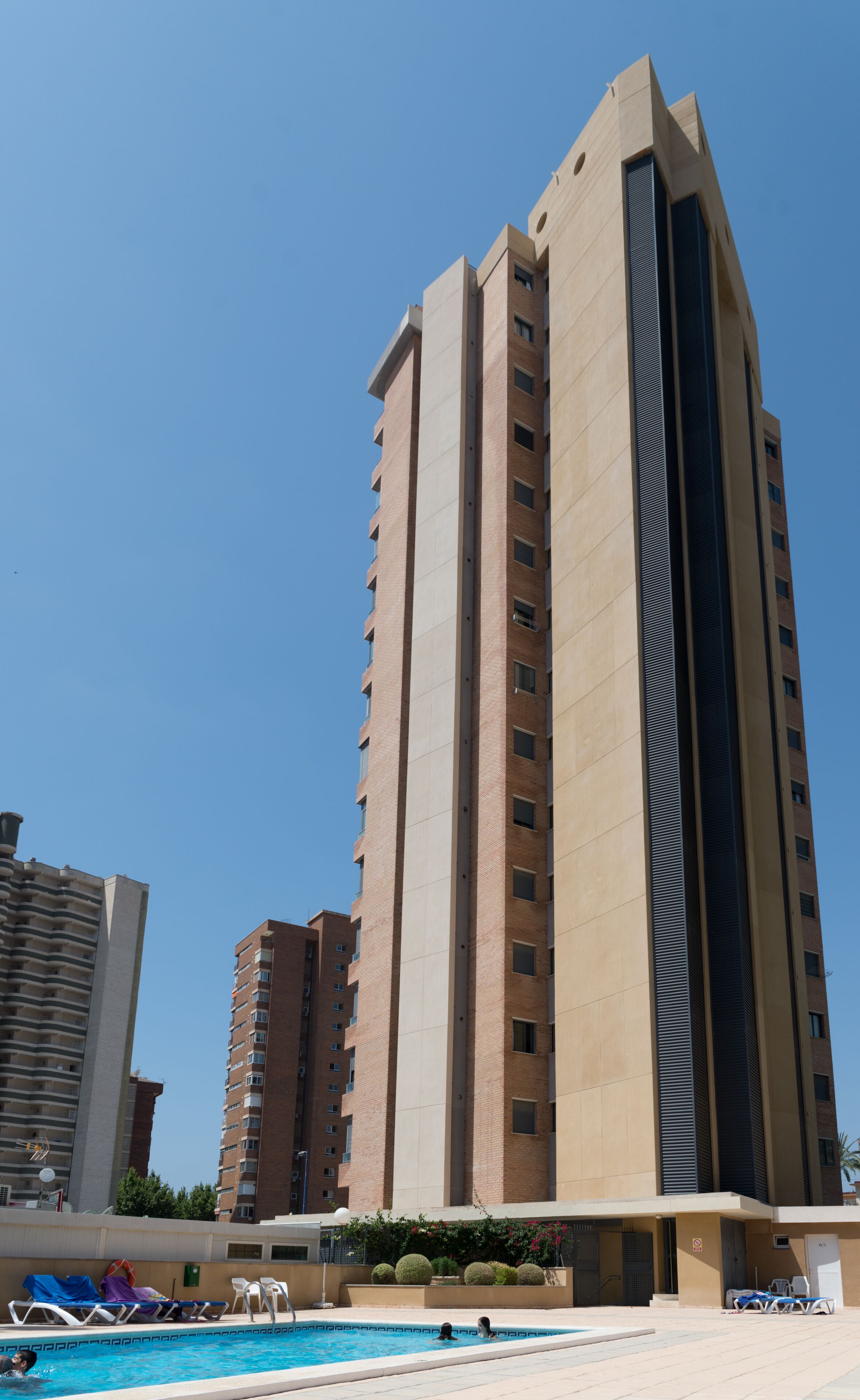 A high-rise building with a swimming pool in the foreground.