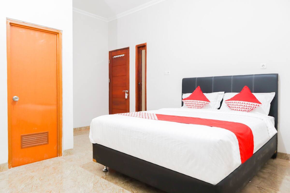 Een hotelkamer met een bed, een deur en een muur.