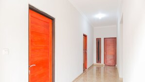 Un pasillo con puertas rojas y piso de baldosas.