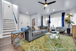 Relax in this inviting living space with a sofa, coffee table, and side table, plus a staircase leading to an upper level.