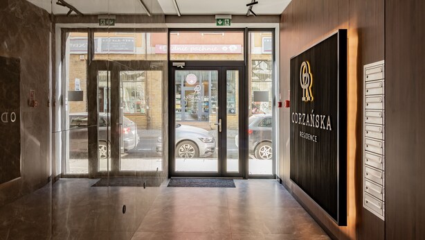 A hotel entrance with glass doors, a reception desk, and a directory on the wall. - Odrzańska Residence by Boogie Apartments (Wroclaw)