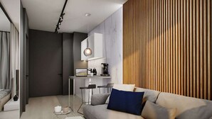 A modern living room with a sofa, a coffee table, and a dining area with a bar. - Odrzańska Residence by Boogie Apartments (Wroclaw)
