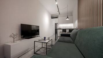 A modern living room with a large flat-screen TV, a green sofa, and a coffee table.