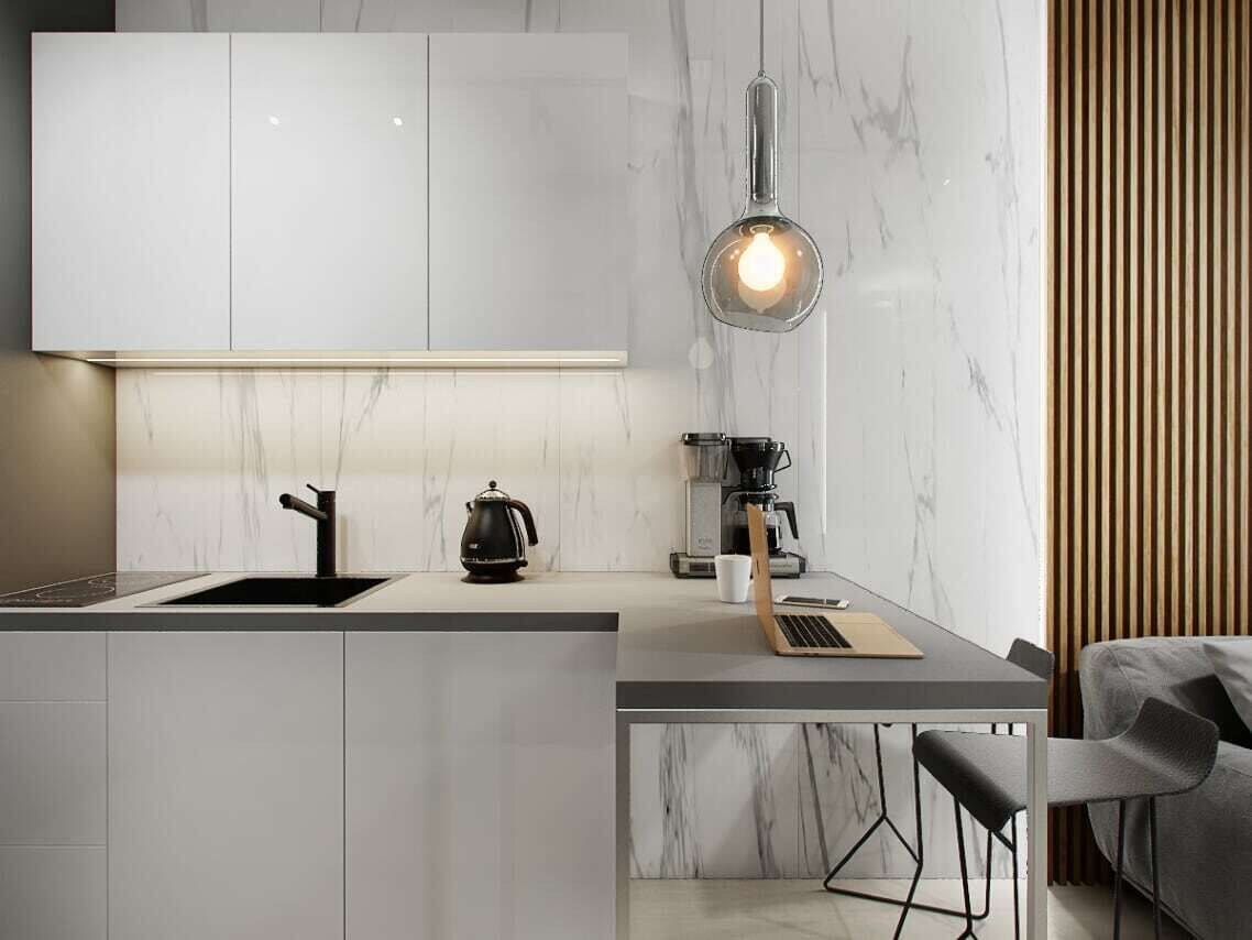 A modern kitchen with a marble backsplash, a coffee machine, and a laptop on the counter.