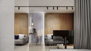 A modern hotel room with a bed, a TV, a desk, and a seating area with a sofa and chairs. - Odrzańska Residence by Boogie Apartments (Wroclaw)