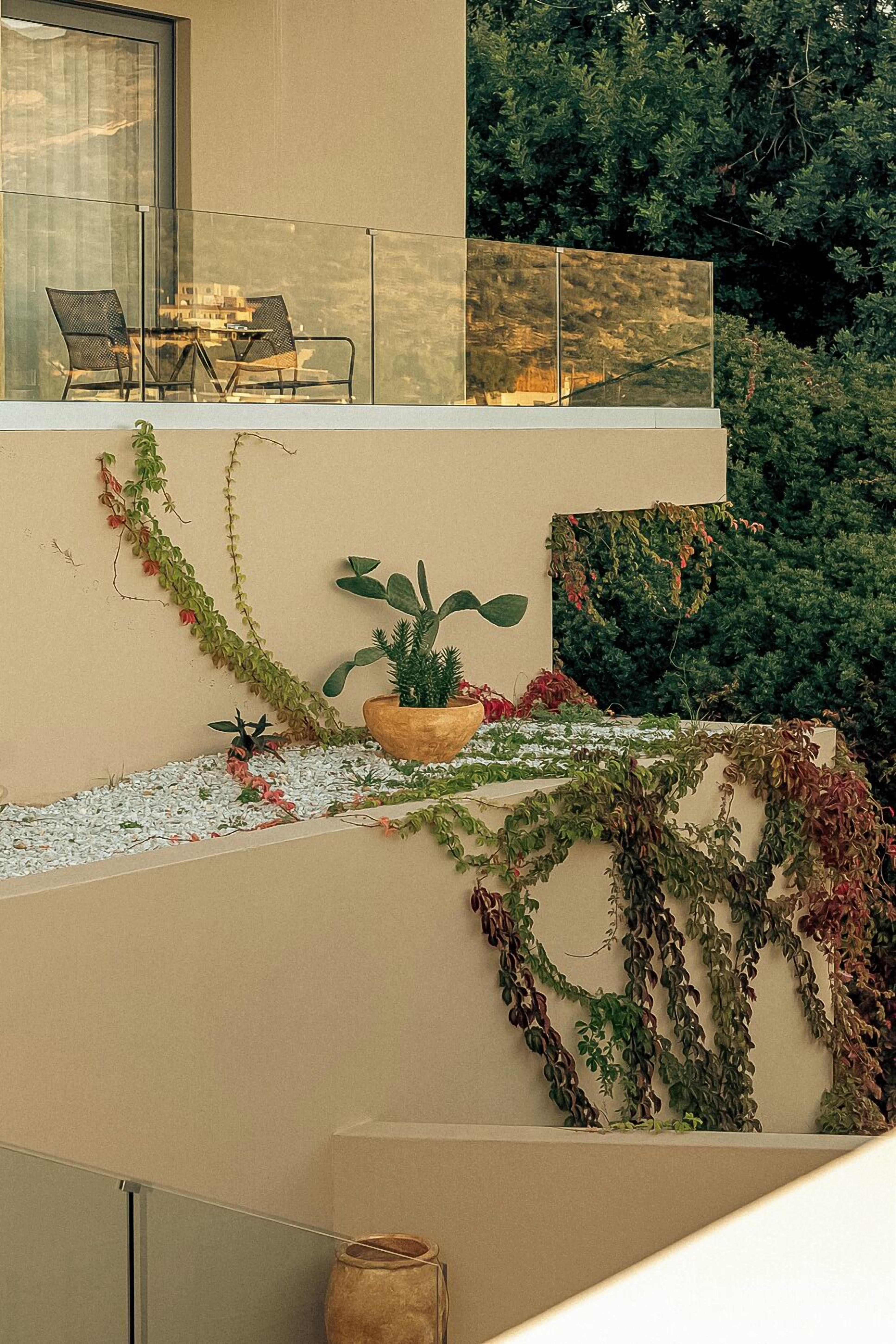 Ein Balkon mit Sitzgelegenheit, einem Blumentopf und einer Wandpflanzhalterung.