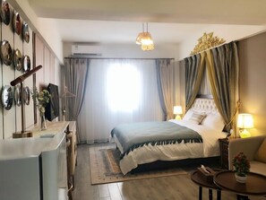 A hotel room with a bed, bedside lamps, a desk, and a chair. - Ruide Apartment Xiaobei Railway Station (Guangzhou)