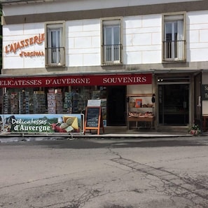 Fachada de una tienda con un letrero que dice "LAJASSERIE JORCIVAL" y otro letrero para "SOUVENIRS D'AUVERGNE".
