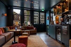 Un espace bar moderne, doté de sièges, d’un comptoir et d’une poubelle.