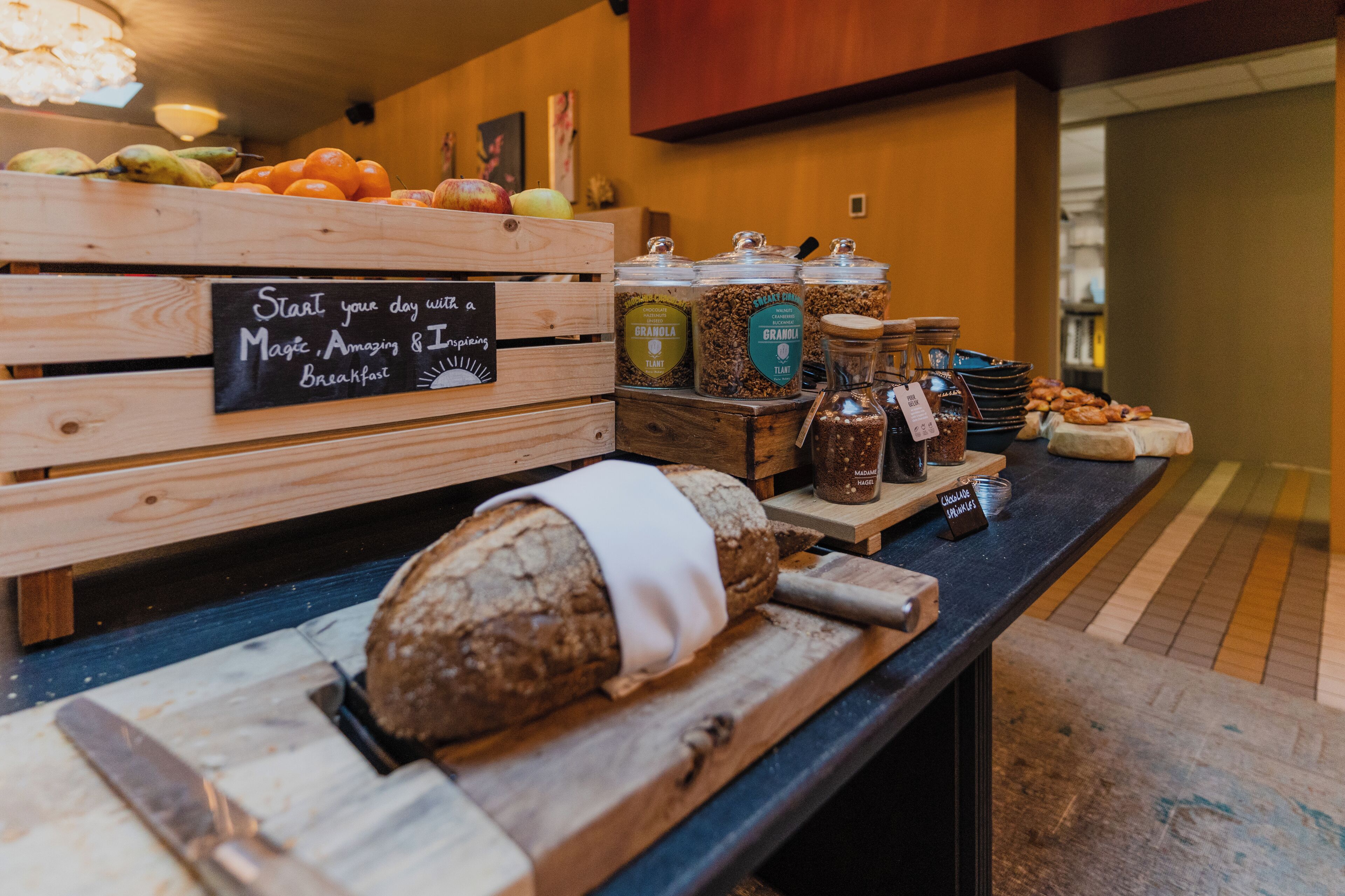 A breakfast buffet with various food items and a sign that reads "Start your day with a Magic, Amazing & Inspiring Breakfast".
