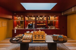 Un buffet de petit-déjeuner proposant une variété d’aliments, avec une verrière au-dessus.