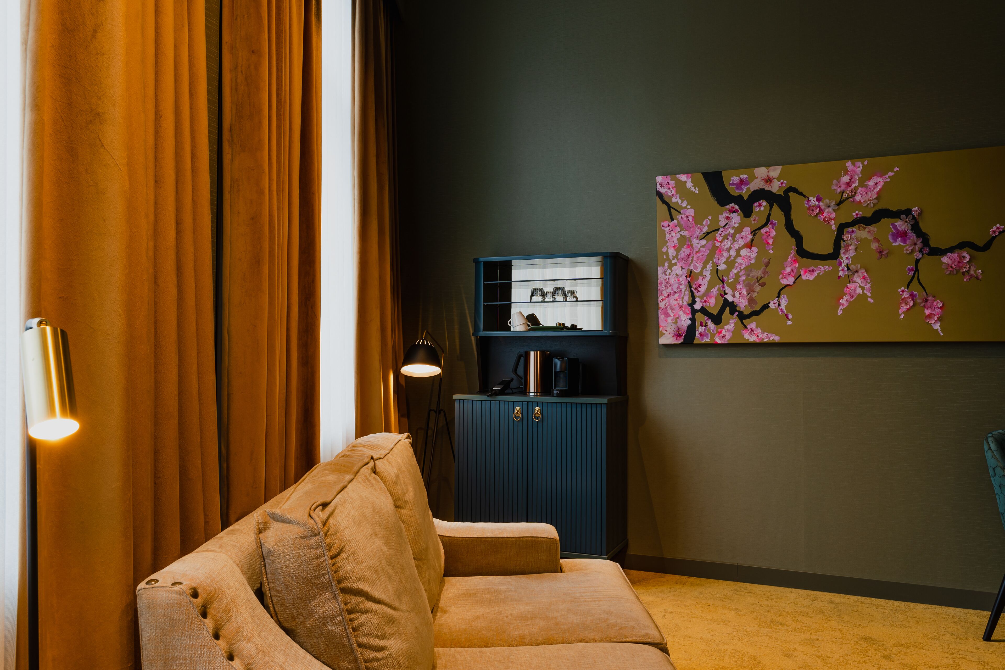 Un salon avec un canapé, un meuble à chaussures et un tableau accroché au mur.
