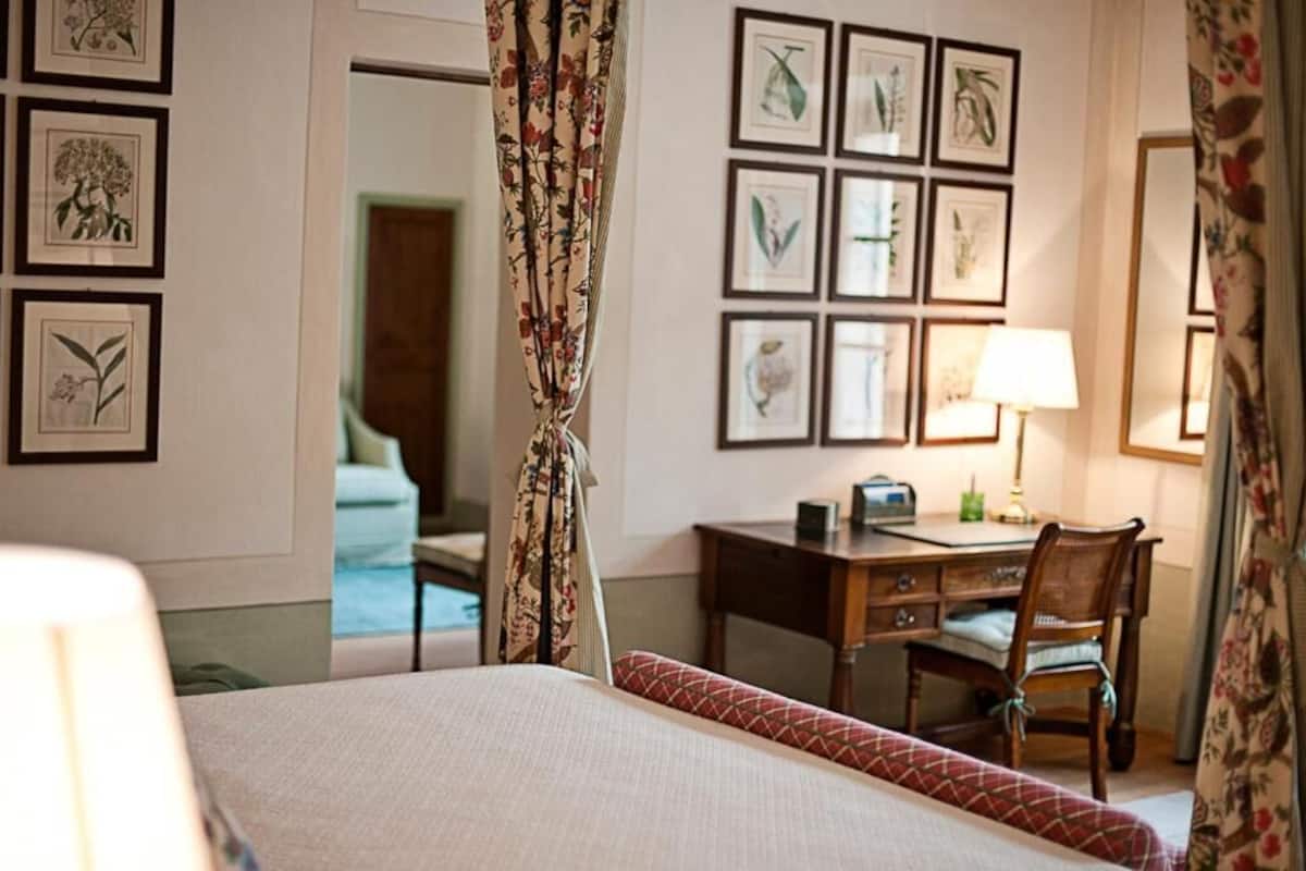 Hotellihuone, jossa on sänky, työpöytä, tuoli ja näkymä uima-altaalle.