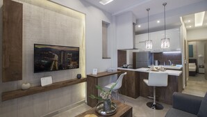 A modern kitchen with a central island, white bar stools, and pendant lighting. - InCity El Flow, Double Flat (Thessaloniki)