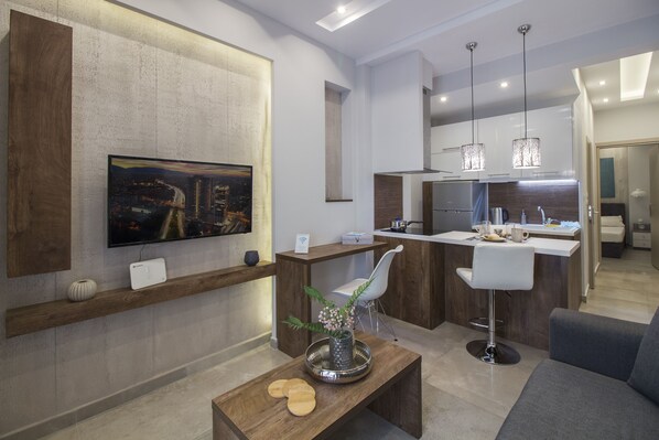 A modern kitchen with a central island, white bar stools, and pendant lighting.