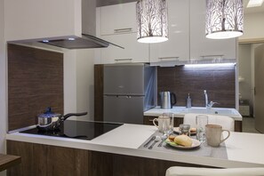 A modern kitchen with a built-in stove, stainless steel appliances, and a dining area with a table set for two.