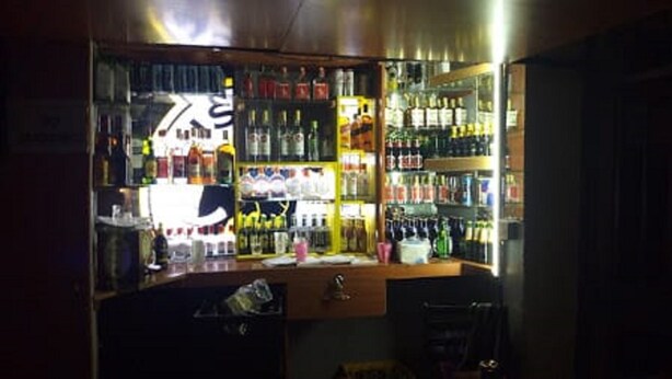 Eine Bar mit Regalen voller Flaschen und einer Theke.