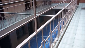 A multi-level atrium with a glass-bottomed pool, metal railings, and a tiled floor. - GMT Guest House (Mai Mahiu)
