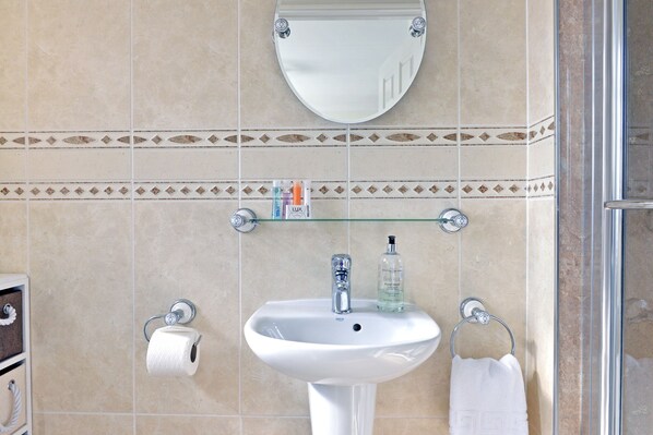 Ein Badezimmer mit Waschbecken, Toilette und Duschbereich.