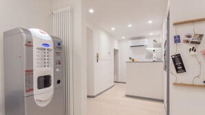 A modern hotel lobby with a self-service kiosk, a reception desk, and a clean, minimalist design. - Santo Spirito Venti (Florence)