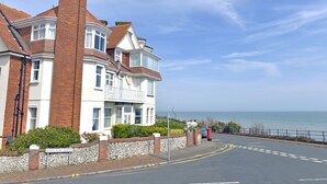 A large, two-story house with a prominent brick chimney and white exterior walls. - Sea Dreams (Eastbourne)