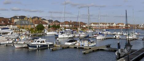 A marina with various boats docked, surrounded by residential buildings.