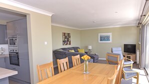 A compact living space with a kitchen, dining area, and seating area. - Beach Garden (Pevensey)