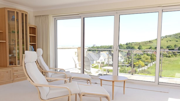 Varanda ampla com vista desobstruída para uma paisagem verde e casas.
