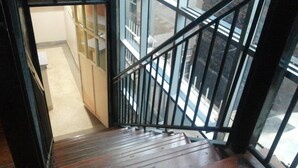 Un escalier en bois avec des rampes en métal menant à l’étage supérieur.