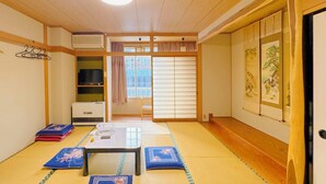 Et traditionelt japansk rum med tatamimåtter, et lavt bord og shoji-skærme.