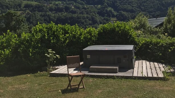 Une montagne avec un chalet en bois au premier plan.