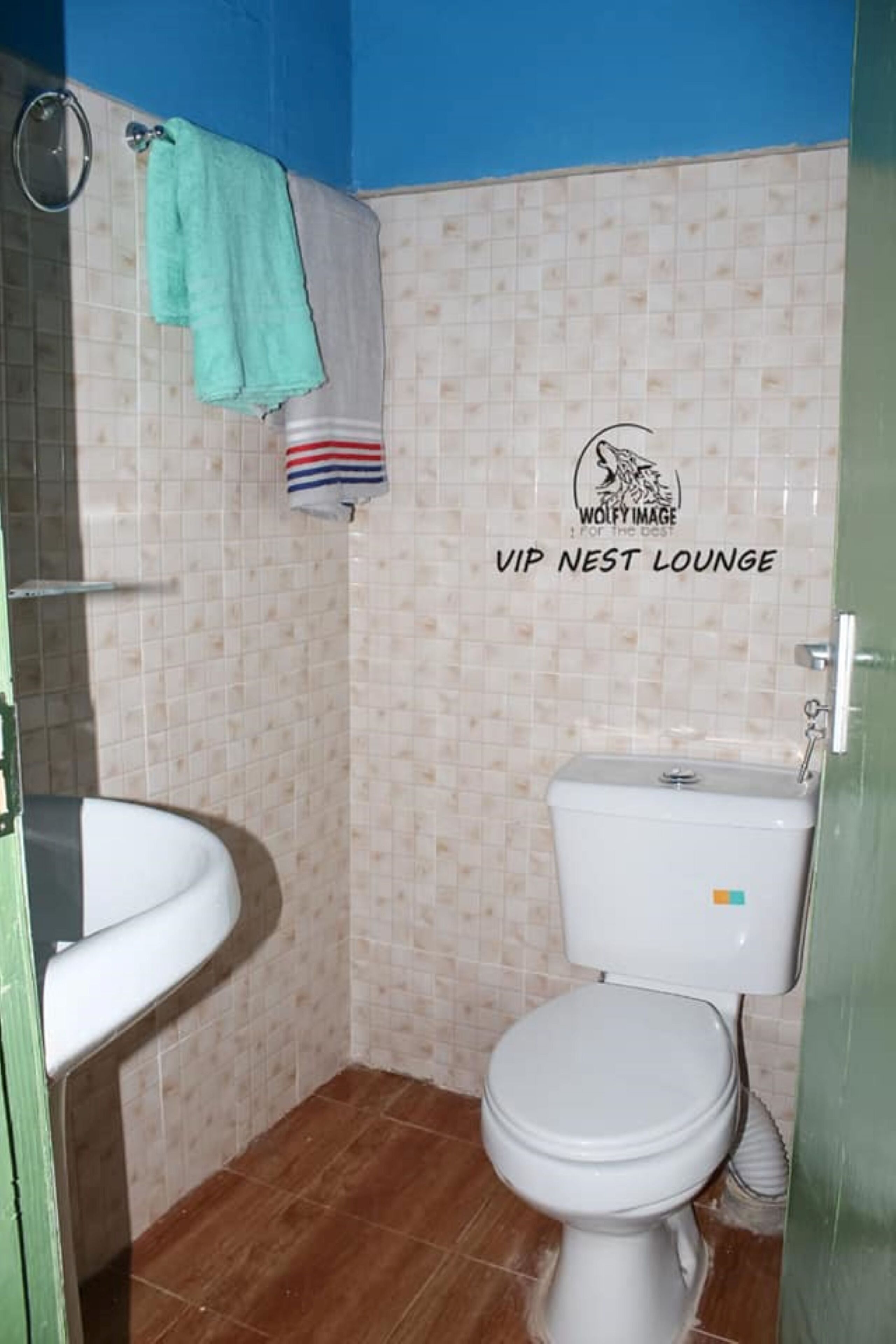 A small bathroom with a toilet, sink, and a shower area.