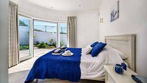 A bedroom with a bed, a nightstand, and a view of the outdoors. - Lila - Stunning sea views from this villa with infinity pool (Sesmarias)