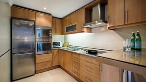 A modern kitchen with stainless steel appliances, wooden cabinets, and a granite countertop. - Lila - Stunning sea views from this villa with infinity pool (Sesmarias)