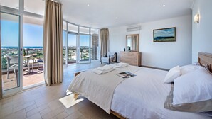A spacious bedroom with a large bed, a balcony with a view, and a modern bathroom. - Lila - Stunning sea views from this villa with infinity pool (Sesmarias)