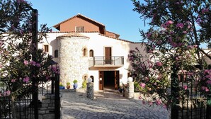 A two-story building with a stone facade, a balcony, and a stone-paved entrance. - Zagamilos Hotel (Pylos-Nestoras)