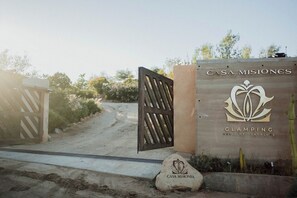 En grind markerar ingången, och det finns en skylt med texten ”Casa Misiones Glamping Valle de Guadalupe”.