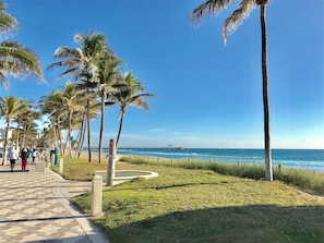 A coastal walkway lined with palm trees and a pier extending into the sea. - Deerfield Beach Townhouse- 2 Blocks to Deerfield Beach  (Deerfield Beach)