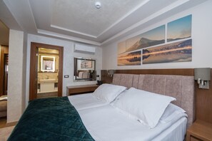 Suite estudio Deluxe | Minibar, caja de seguridad en la habitación y escritorio 