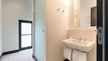 A modern bathroom with a white sink, a mirror, and a towel rack.