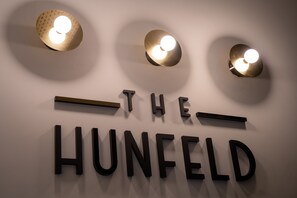 A wall with the text "THE HUNFELD" and three wall-mounted lights.