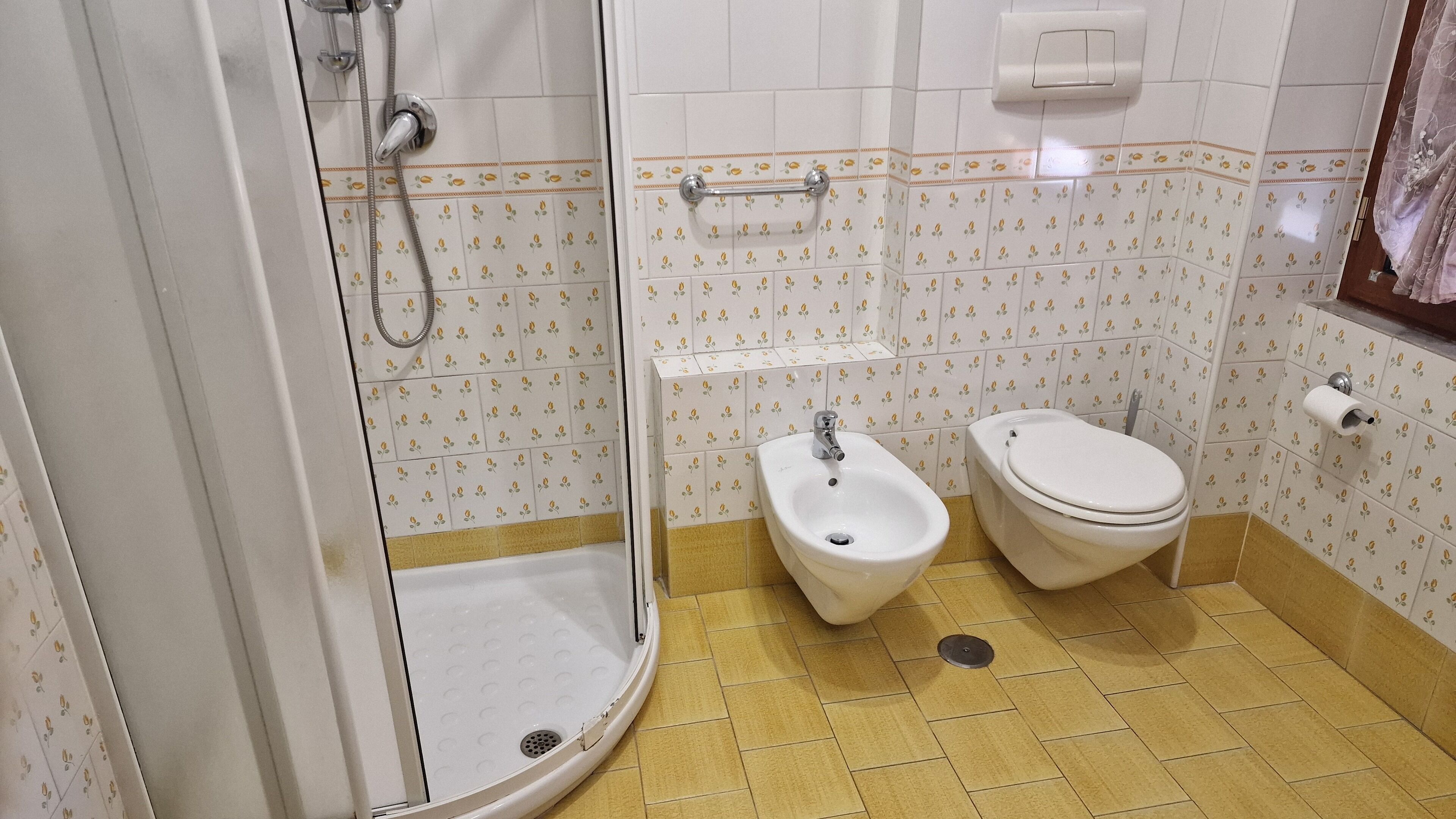 Une salle de bain équipée d’une douche, d’un bidet, de toilettes et d’un porte-serviettes.