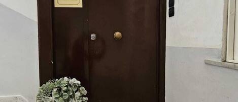 A dark wooden door with a plaque reading "VITTORIA HOLIDAY HOME".