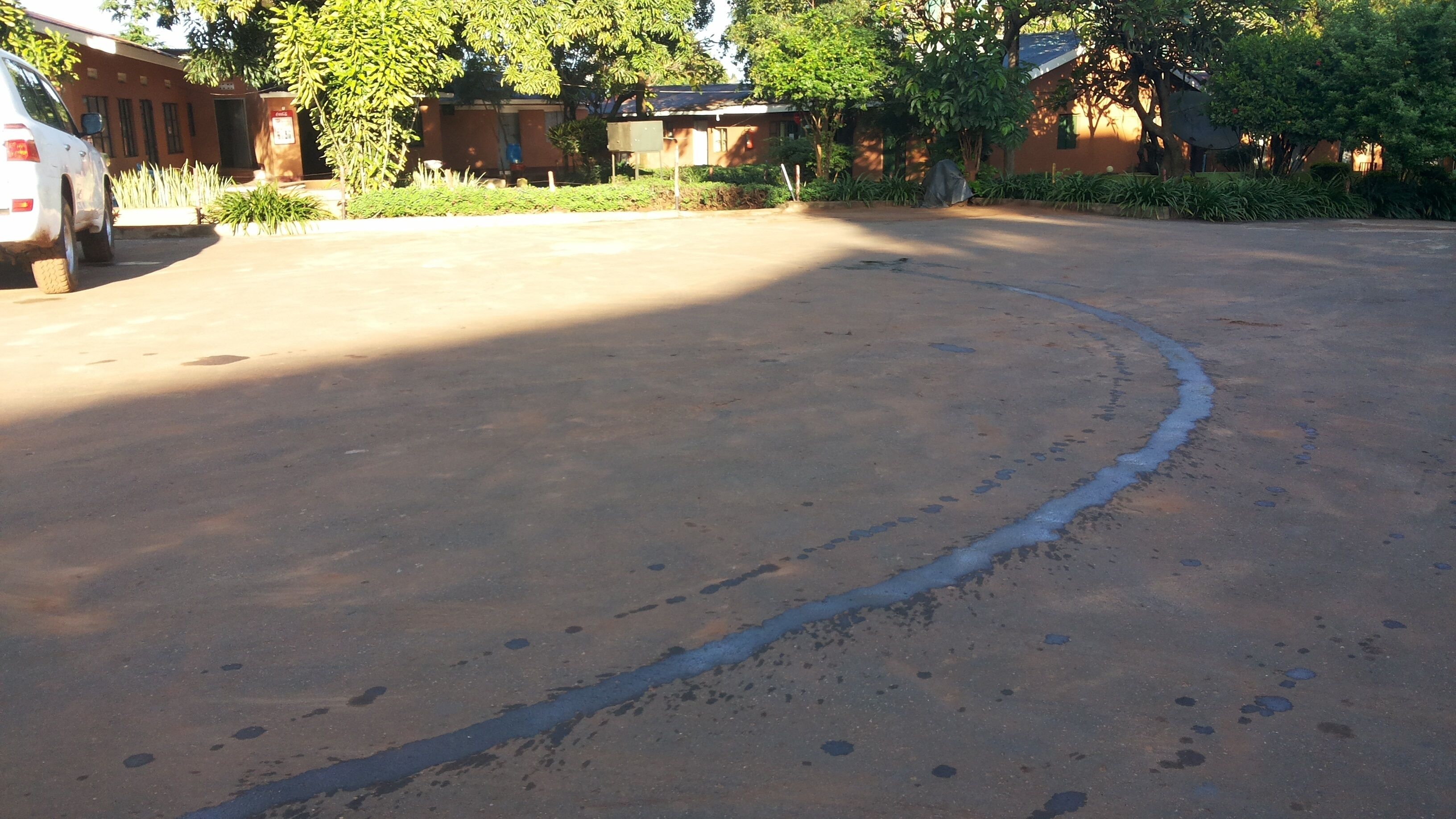 A parking area with a white car parked on the left.