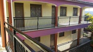 A two-story building with balconies, a staircase, and a door labeled "NISSAN".