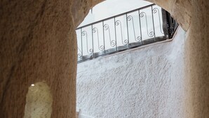Uma escadaria de pedra com grade de ferro forjado que leva a um nível superior.