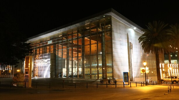 A modern building with large glass windows and a prominent entrance.