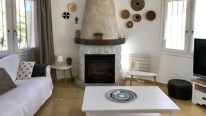 A living room with a fireplace, a sofa, a coffee table, and a TV.